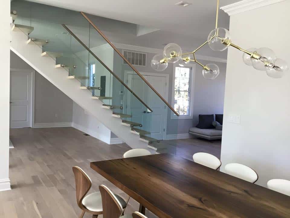 Modern glass staircase with sleek safety railing and minimalist design. Stunning glass staircase with modern railing in a bright, elegant home interior.