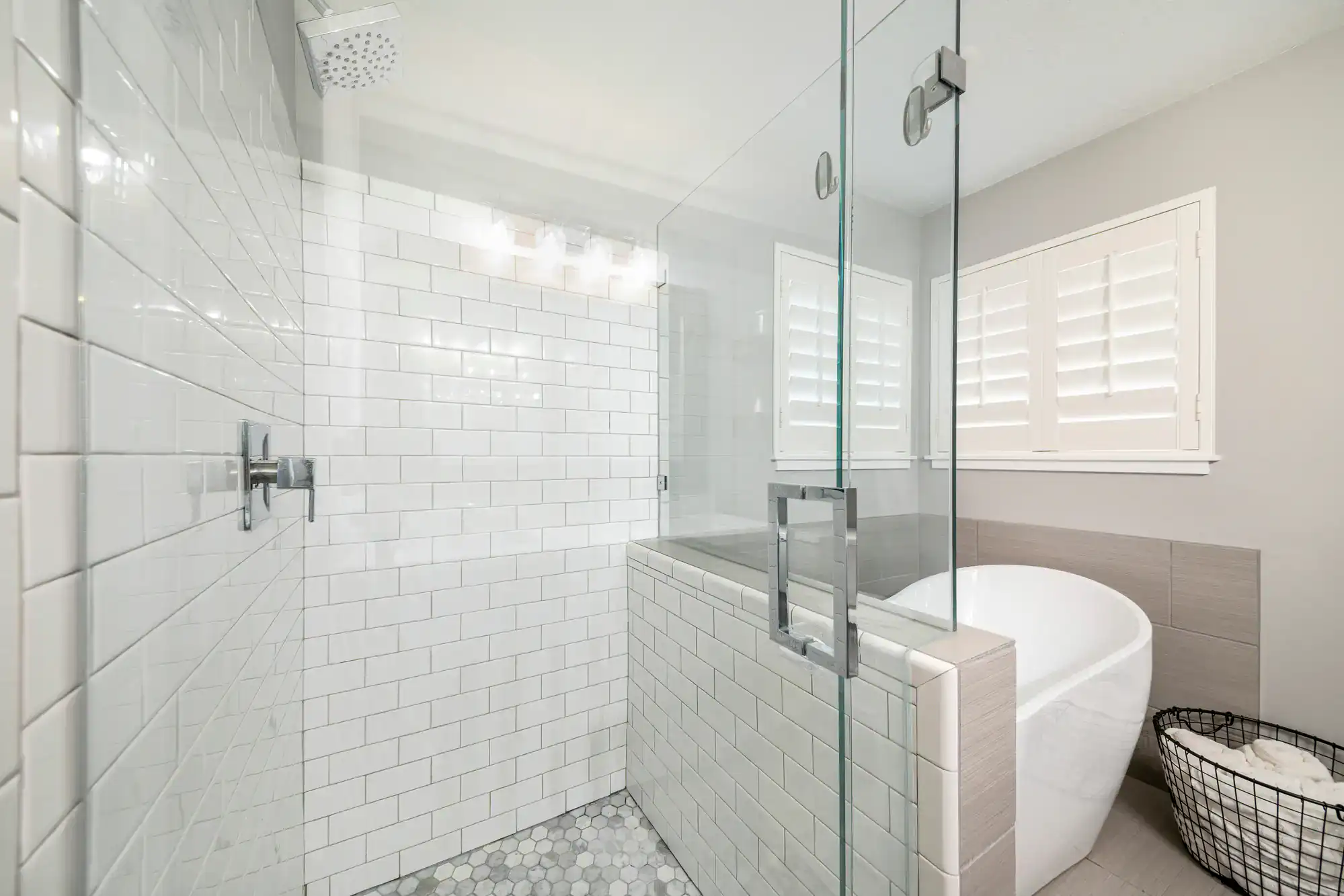 Beautiful modern bathroom with glass shower door, white tiles, and soaking tub. Perfect for luxury bathroom upgrades.