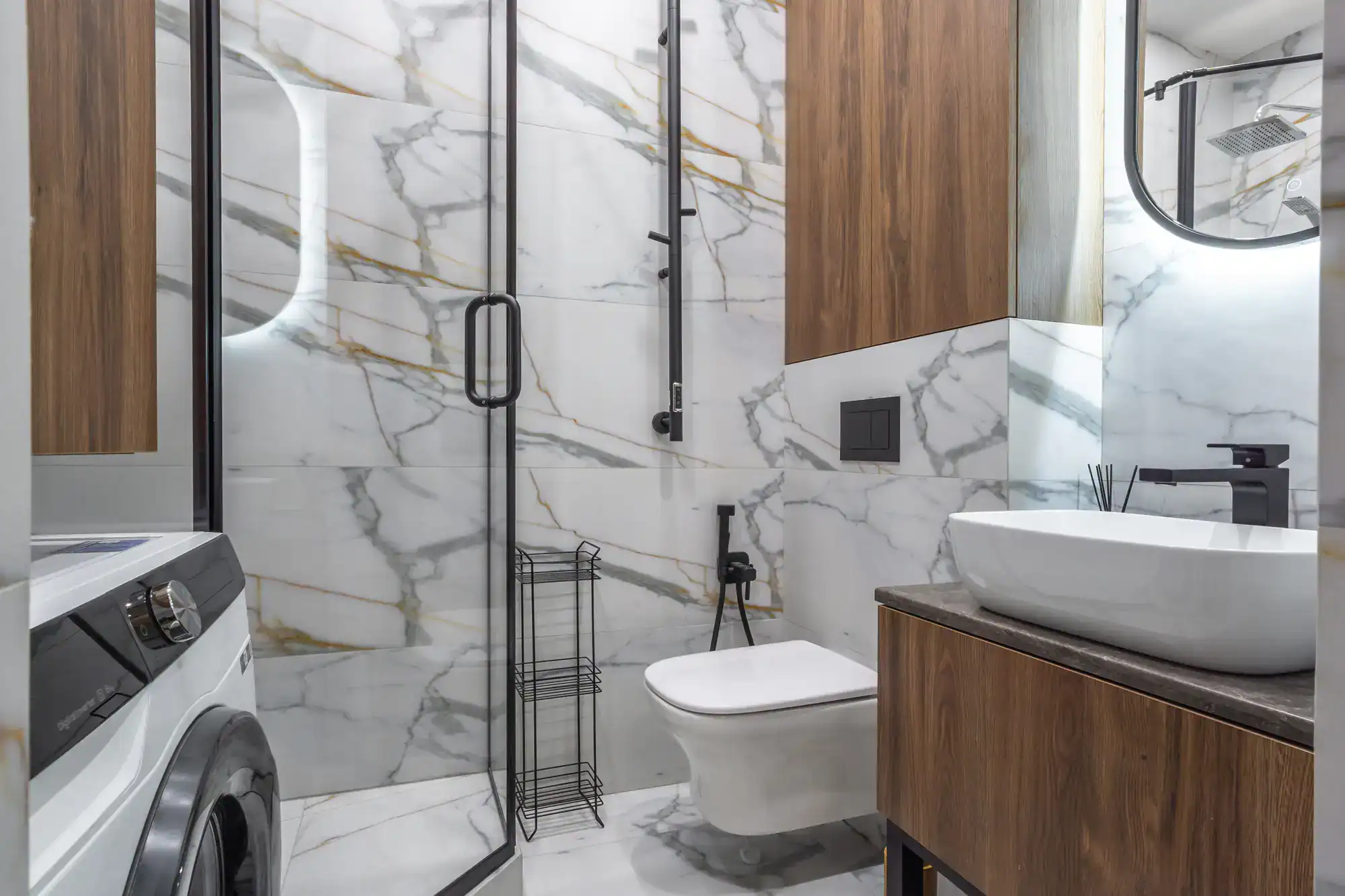 Luxury bathroom with black-framed glass shower, marble accents, and contemporary fixtures.