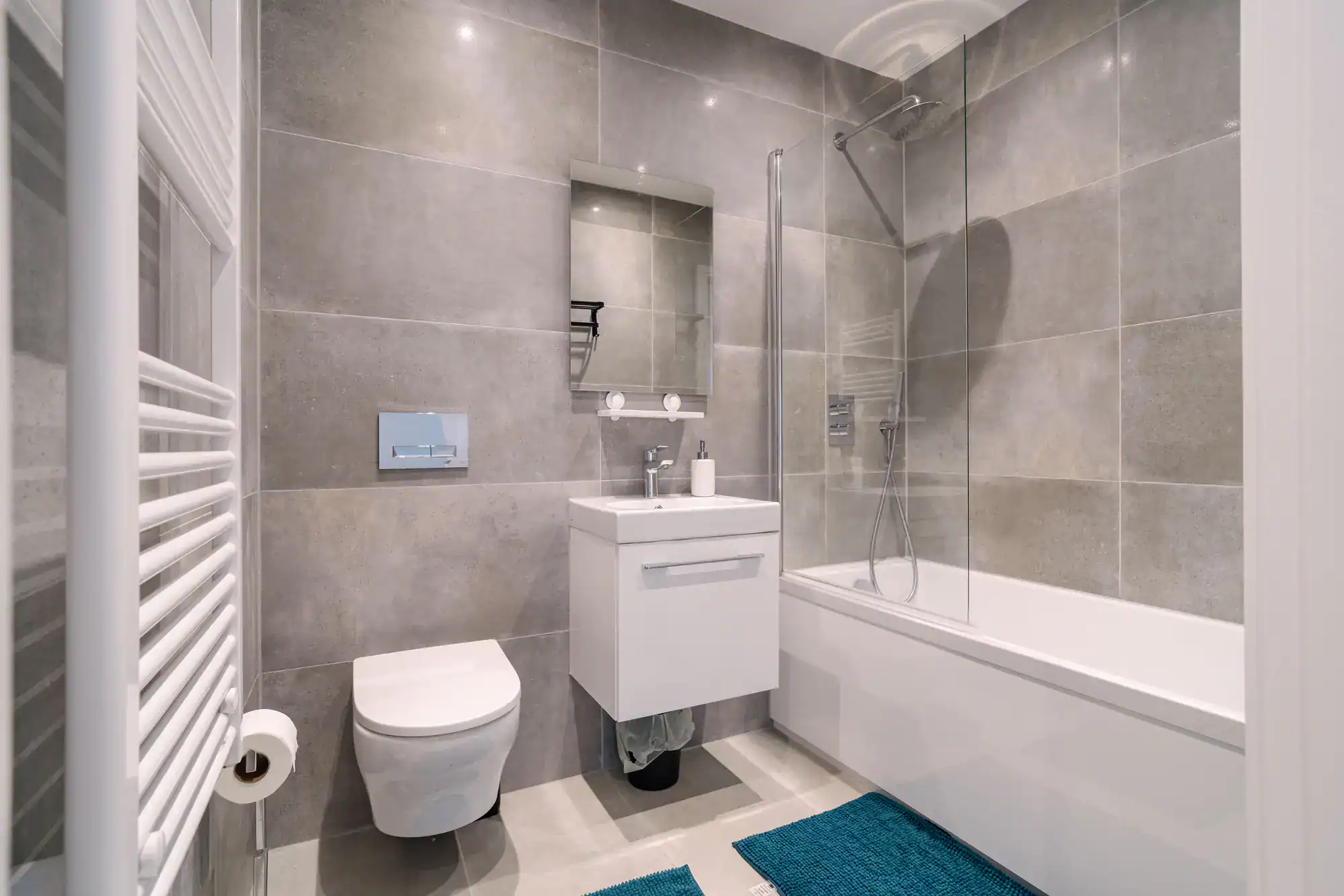 Bright bathroom with sleek glass shower door and contemporary fixtures.